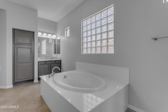 bathroom featuring a washtub, tile patterned floors, and vanity