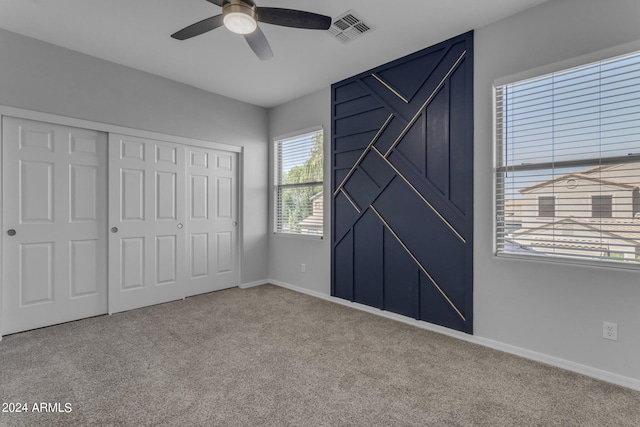 unfurnished bedroom with light carpet, a closet, and ceiling fan