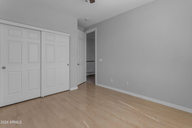 unfurnished bedroom featuring ceiling fan, a closet, and light hardwood / wood-style floors