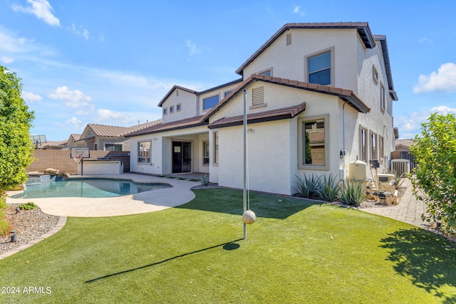 rear view of property featuring a fenced in pool, a patio, a yard, and cooling unit