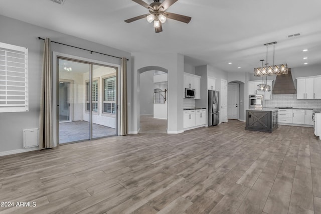 unfurnished living room with ceiling fan and light hardwood / wood-style floors