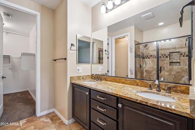 9921 E Acceleration Dr, Mesa, AZ 85212 - bathroom with double vanity, a shower stall, a walk in closet, and baseboards