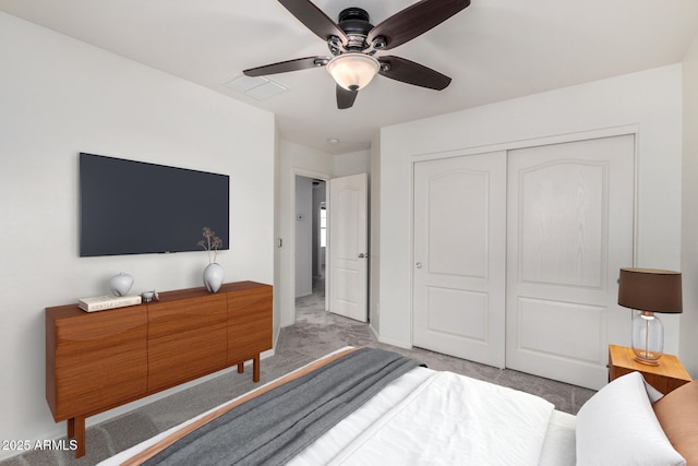 carpeted bedroom with baseboards, visible vents, a closet, and ceiling fan