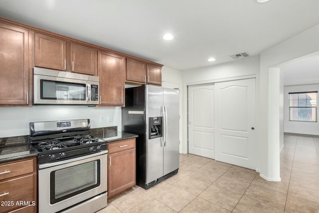 kitchen with visible vents, brown cabinets, appliances with stainless steel finishes, and light tile patterned flooring