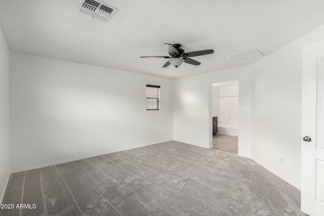 empty room with visible vents, carpet flooring, and a ceiling fan