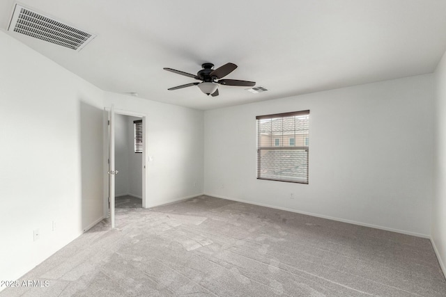 spare room featuring baseboards, light colored carpet, visible vents, and ceiling fan