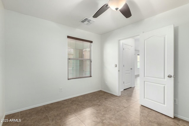 unfurnished bedroom with light tile patterned floors, visible vents, baseboards, and a ceiling fan