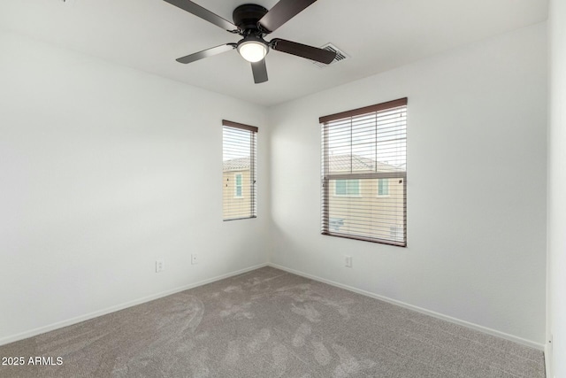 carpeted empty room featuring visible vents, baseboards, and ceiling fan