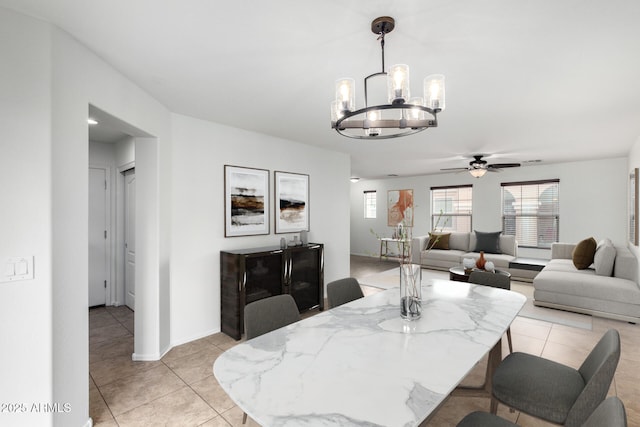 dining area with light tile patterned floors, a ceiling fan, and baseboards