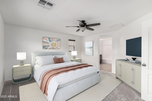 bedroom with visible vents, light colored carpet, ensuite bath, and a ceiling fan