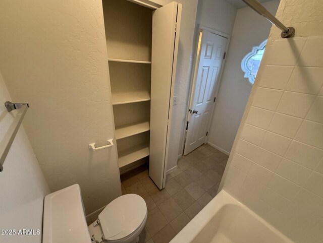 16602 N 25th St Unit 217, Phoenix, AZ 85032 - bathroom with tile patterned floors, toilet, a textured wall, and shower / bath combination