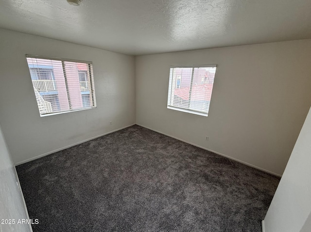 16602 N 25th St Unit 217, Phoenix, AZ 85032 - unfurnished room featuring plenty of natural light, dark colored carpet, baseboards, and a textured ceiling