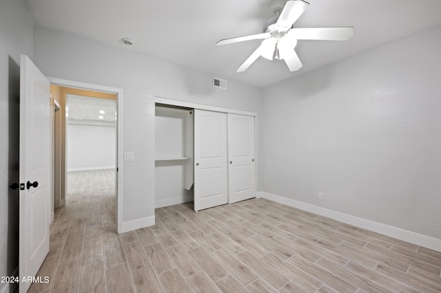 unfurnished bedroom with a closet, light hardwood / wood-style floors, and ceiling fan