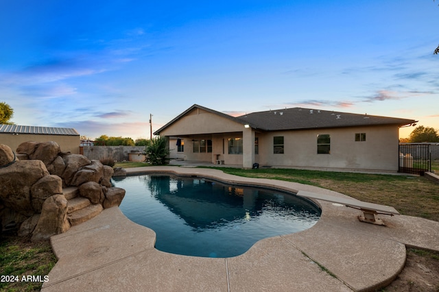 pool at dusk with a patio area