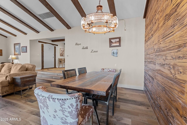 dining room featuring visible vents, baseboards, beamed ceiling, an inviting chandelier, and wood finished floors