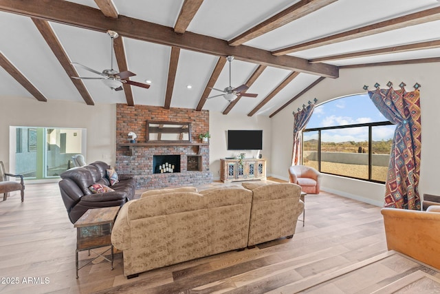 living area with light wood-type flooring, lofted ceiling with beams, a fireplace, baseboards, and ceiling fan