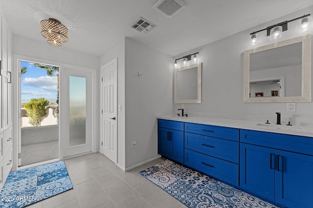 bathroom with double vanity, visible vents, tile patterned floors, and a sink