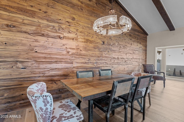 dining room featuring wooden walls, high vaulted ceiling, an inviting chandelier, light wood-style flooring, and beam ceiling