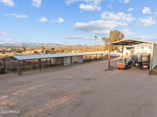 view of vehicle parking with an exterior structure and a mountain view