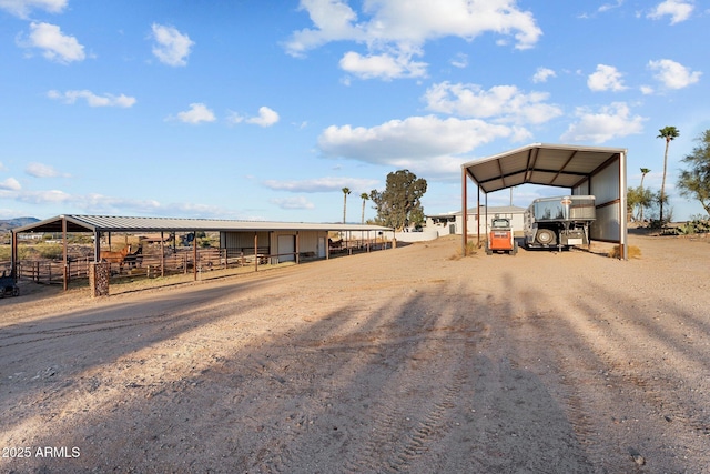 exterior space featuring a carport, an exterior structure, driveway, and an outdoor structure