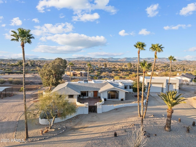 view of front of property featuring a fenced front yard, a mountain view, a garage, and a gate