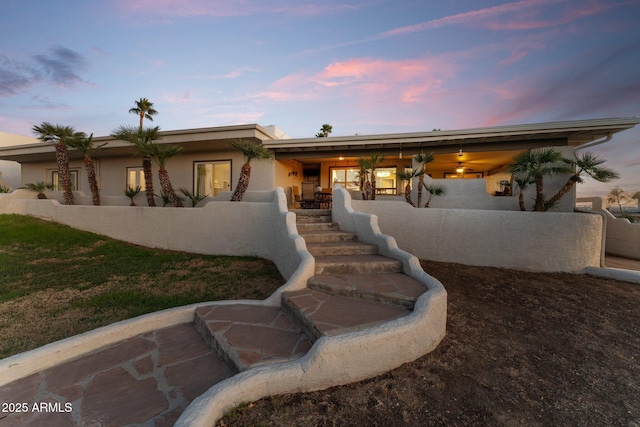 view of front of home featuring stucco siding and stairs