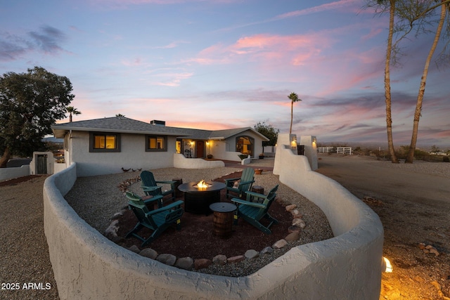 view of front of home featuring an outdoor fire pit and fence