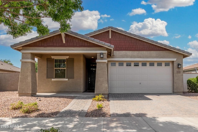view of front of house featuring driveway, stucco siding, and a garage