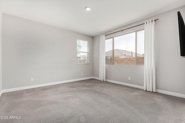 carpeted spare room featuring baseboards