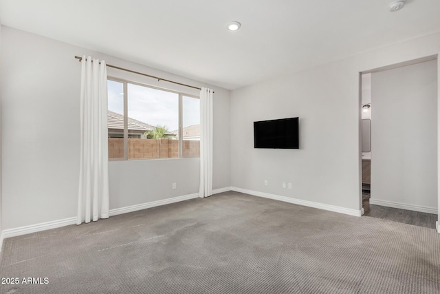 carpeted empty room with baseboards, a smoke detector, and recessed lighting