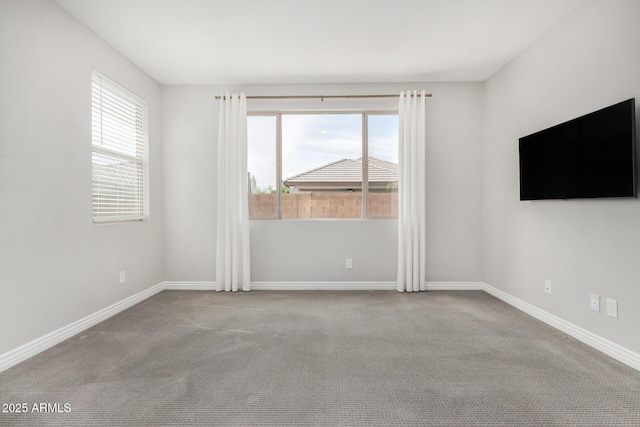 carpeted spare room with baseboards