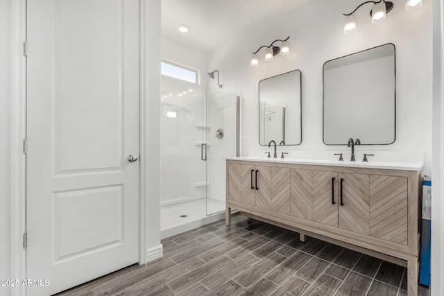 bathroom featuring a walk in shower, wood finish floors, and double vanity