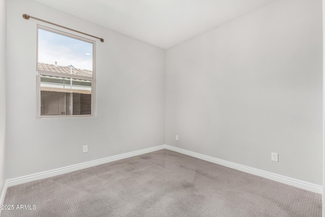 spare room featuring baseboards and carpet