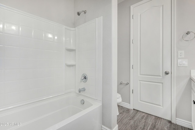 full bathroom with toilet, wood finished floors, baseboards, washtub / shower combination, and vanity