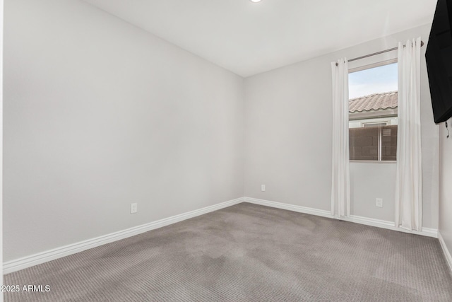 unfurnished room with carpet floors and baseboards