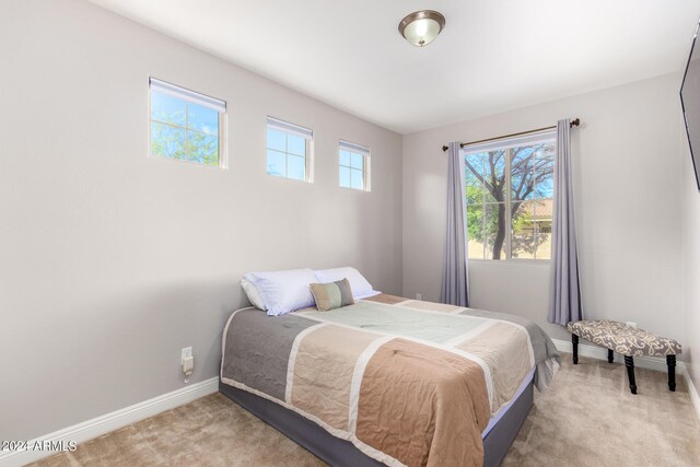 carpeted bedroom featuring multiple windows