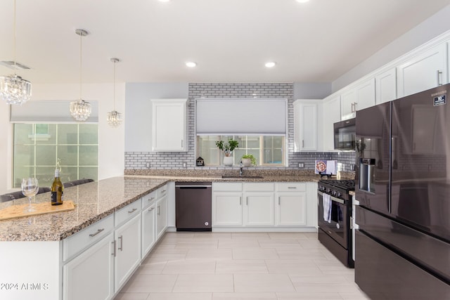 kitchen with white cabinets, hanging light fixtures, kitchen peninsula, a chandelier, and black appliances