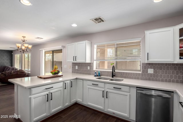 kitchen featuring visible vents, a sink, stainless steel dishwasher, a peninsula, and light countertops