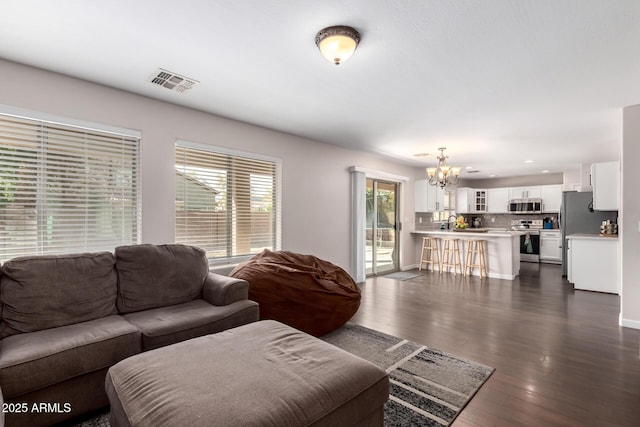 living area with recessed lighting, dark wood-style floors, visible vents, and a chandelier