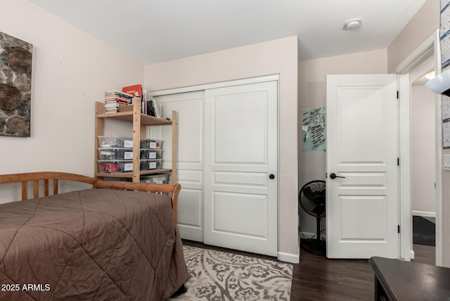bedroom with a closet, baseboards, and wood finished floors