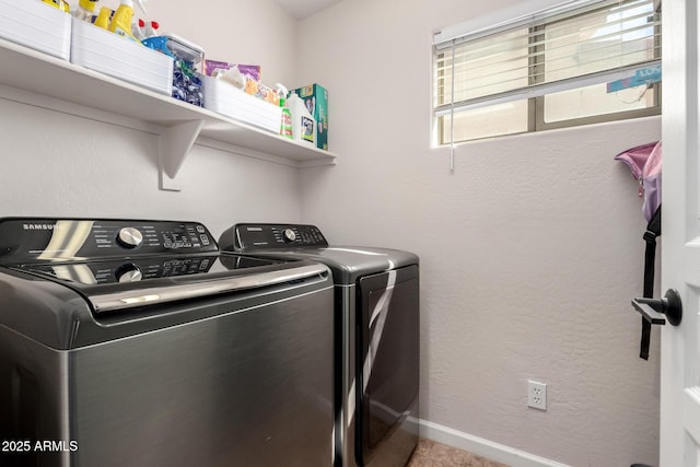 washroom featuring laundry area, separate washer and dryer, baseboards, and a textured wall