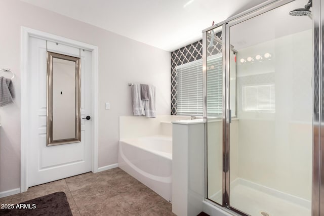 bathroom with a bath, a shower stall, tile patterned floors, and baseboards