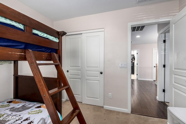 unfurnished bedroom with a closet, visible vents, carpet flooring, and baseboards