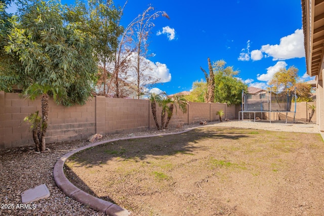 view of yard featuring a fenced backyard and a trampoline