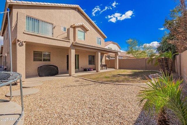 back of property featuring a patio, a trampoline, and stucco siding