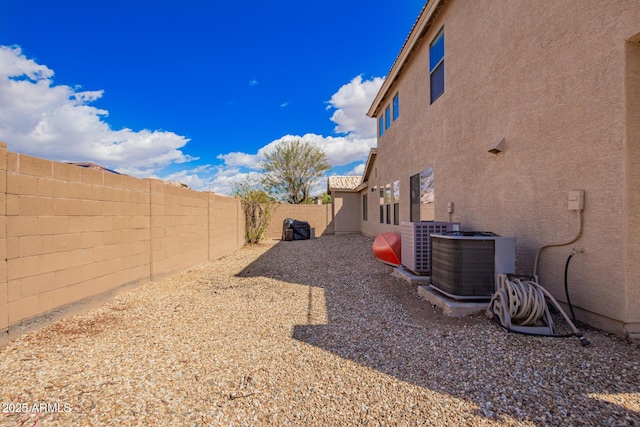 view of yard featuring central air condition unit and a fenced backyard