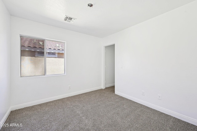 carpeted spare room with visible vents and baseboards