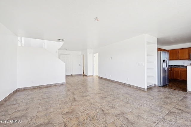 unfurnished living room with visible vents and baseboards