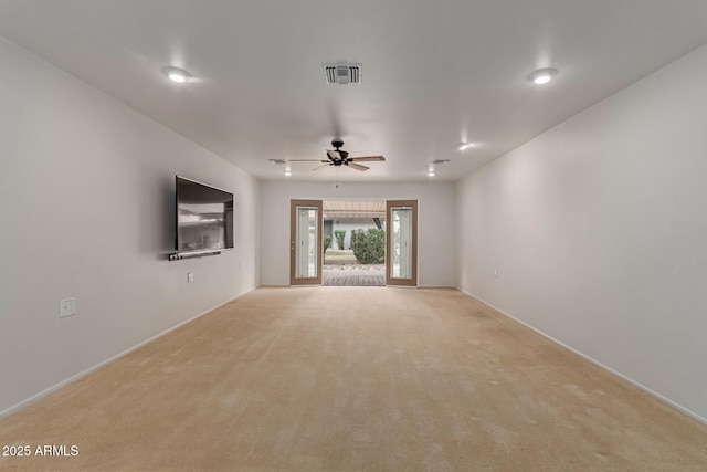 spare room with a ceiling fan, visible vents, and light carpet