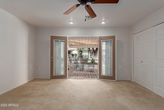 carpeted empty room with a ceiling fan and visible vents